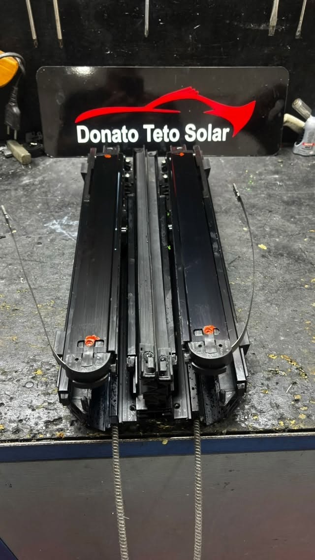 Mecanismo de teto solar desmontado na bancada da oficina